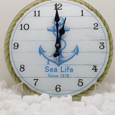 Relógio redondo com âncora azul e texto Sea Life Since 1978 sobre superfície de plástico bolha