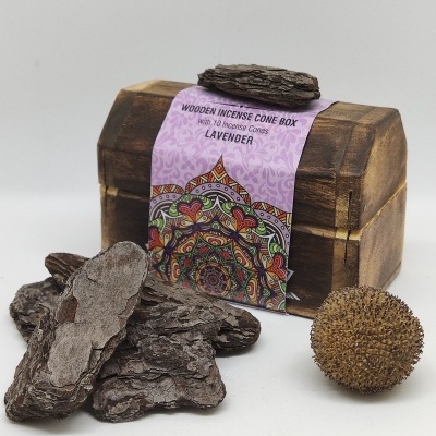 Caixa de incenso em madeira com etiqueta roxa e cascas de madeira ao redor