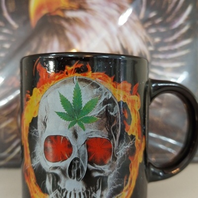 Caneca preta com caveira e folha verde na testa