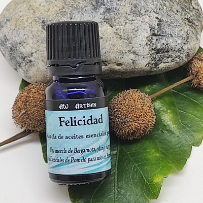 Frasco de óleo essencial azul com rótulo em folha verde, pedra cinza e bolas castanhas