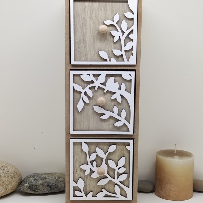 Armário de três gavetas com decoração de ramos e pássaros em madeira clara e branca