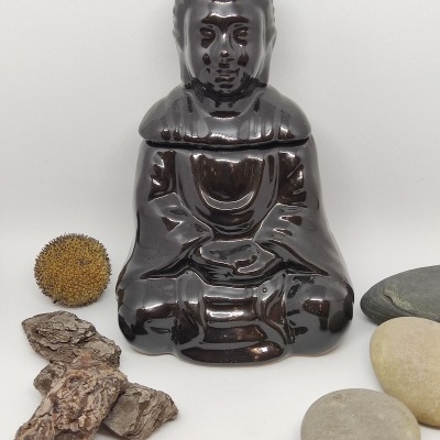 Figura de Buda em cerâmica castanha brilhante com pedras e casca de árvore sobre fundo branco