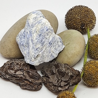 Pedras bege claro, pedra branca com veios azuis, casca de árvore e bolas secas castanho-alaranjadas