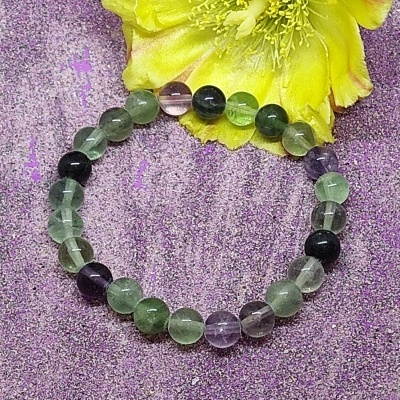 Pulseira de esferas coloridas e translúcidas, com flor amarela ao fundo