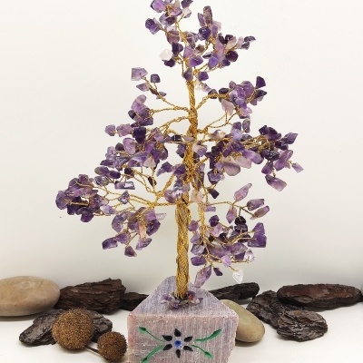 Árvore decorativa de arame com pedras ametista sobre base de pedra rosa com padrão