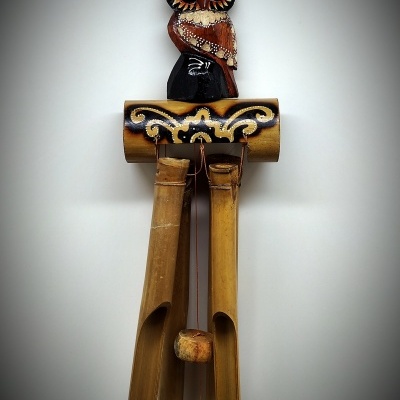 Cata-vento decorativo de madeira com figura de coruja e tubos de bambu suspensos