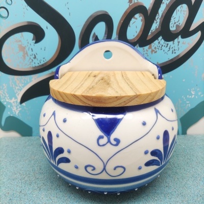 Recipiente de cerâmica branca e azul com tampa de madeira e fundo com texto Soda