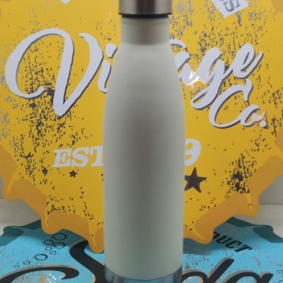 Garrafa térmica branca com tampa e base de aço inoxidável contra fundo amarelo e azul com texto vintage