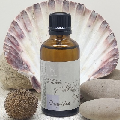 Frasco âmbar com essência para brumizador e elementos naturais ao redor