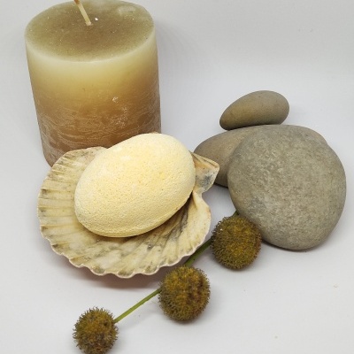 Vela, pedras, concha, esponja e flores secas sobre fundo branco