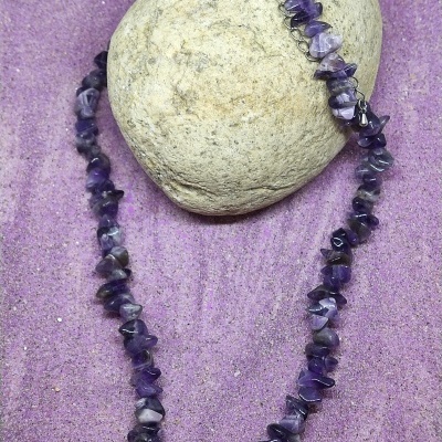 Colar de contas de pedra roxa em areia roxa com pedra cinza ao fundo
