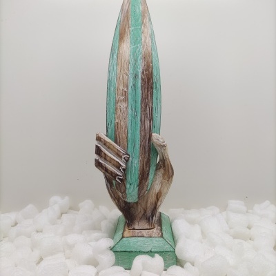 Escultura de mão segurando prancha de surf verde e castanha em base verde