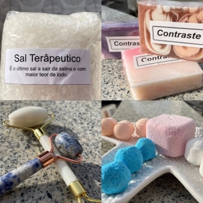 Produtos de cuidados pessoais incluindo sal terapêutico, sabonetes com etiqueta Contraste, rolo de massagem facial em pedra e bombas de banho coloridas