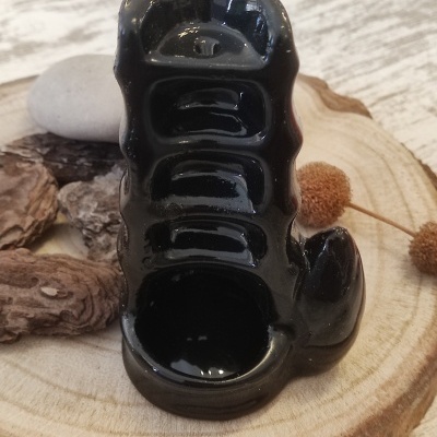 Porta incenso cerâmico preto em base de madeira com troncos e pedras