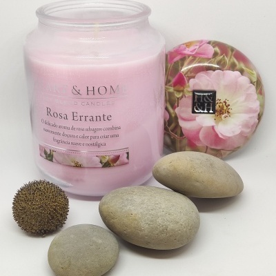 Vela perfumada rosa com tampa floral e pedras cinzentas