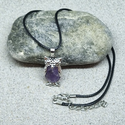 Colar com pendente de coruja prateada e pedra roxa sobre pedra cinza