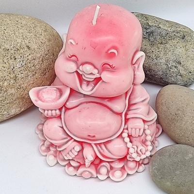 Vela rosa em forma de Buda sorridente com quatro pedras ao redor