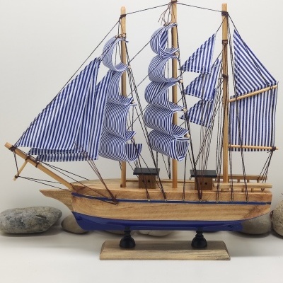 Barco de vela decorativo em madeira com velas azuis e brancas listradas