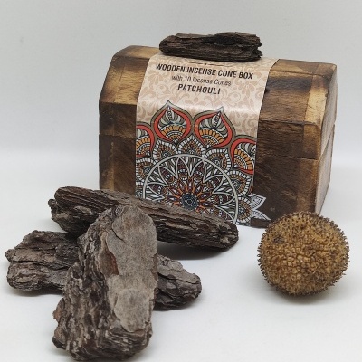 Caixa de madeira para cones de incenso com etiqueta e pedaços de casca de árvore e esfera castanha