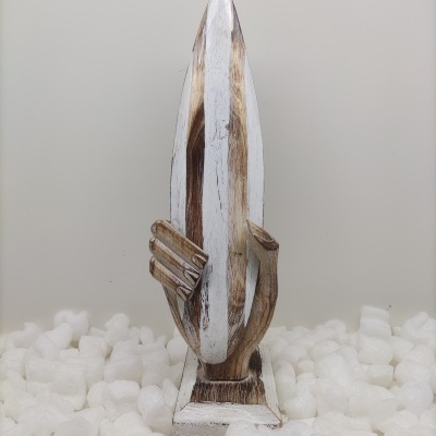 Escultura de madeira de uma mão segurando uma prancha de surf em branco e castanho