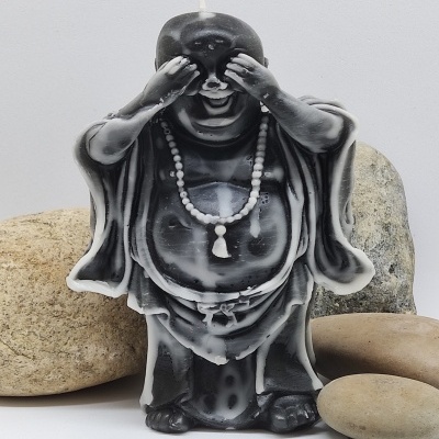Vela decorativa de Buda tapando os olhos com padrão marmoreado preto e branco e pedras naturais ao redor
