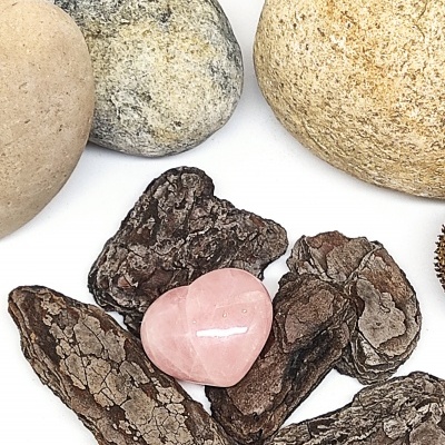 Pedras naturais variando entre cinzento, bege, castanho e uma pedra rosa em forma de coração