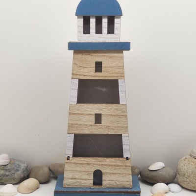 Lanterna decorativa em forma de farol azul e madeira com pedras e conchas