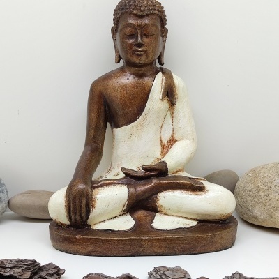 Estátua de Buda em cores castanho e creme com pedras decorativas em volta