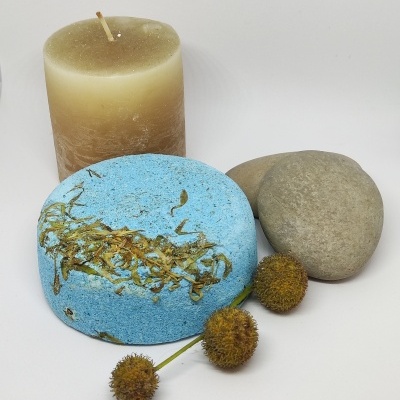 Conjunto com vela castanha, pedra cinza, bola azul com ervas e flores secas.