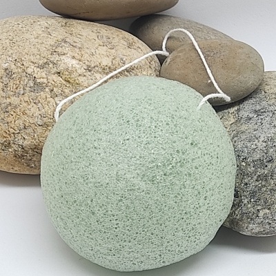 Esponja verde com cordão sobre pedras castanhas e cinzentas