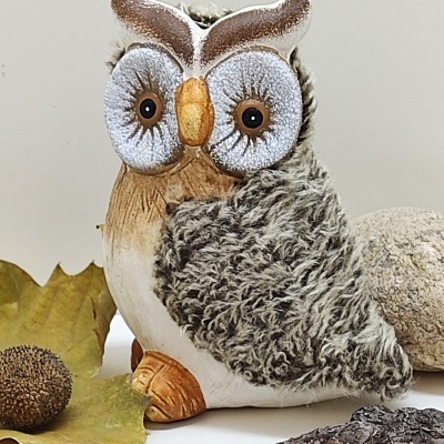 Estátua decorativa de coruja com asas cinzentas texturizadas e olhos grandes em fundo branco