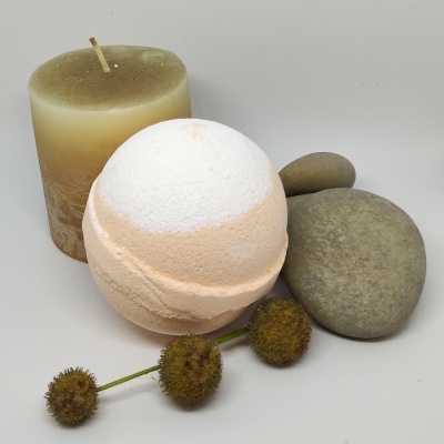 Vela castanha, bola de banho branca e salmão, pedras cinzentas e flores secas