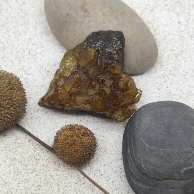 Três pedras e frutos secos espinhosos marrons sobre superfície clara