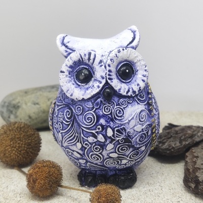 Figura decorativa de coruja em cerâmica azul e branca com olhos pretos
