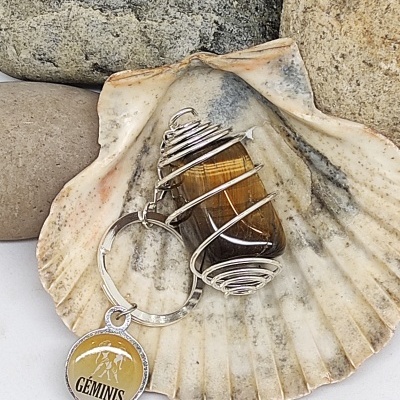 Porta-chaves com pedra castanha em arame prateado e pendente GÉMINIS numa concha