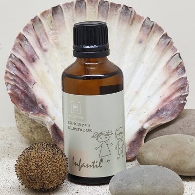 Frasco âmbar com rótulo infantil em areia com concha e pedras