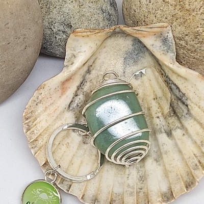 Chaveiro com pedra verde e medalhão CANCER sobre concha e pedras