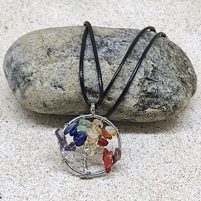 Colar com pendente de árvore da vida com pedras coloridas sobre pedra cinza