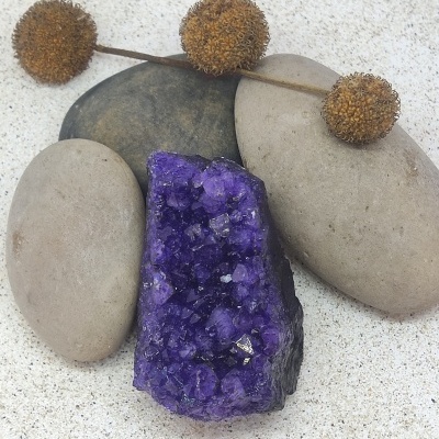 Cristal roxo de ametista com pedras lisas e ramos secos castanhos