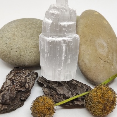 Cristal branco translúcido com pedras e elementos naturais em fundo branco