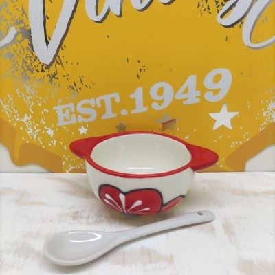 Mini taça vermelha e branca em cerâmica com colher e fundo amarelo com texto vintage