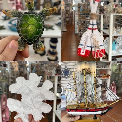 Objetos decorativos náuticos: tartaruga, velas, coral e veleiro em loja