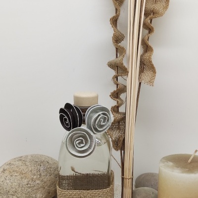 Frasco decorativo em vidro com flores de tecido, pedras, velas e hastes de madeira com fitas rústicas