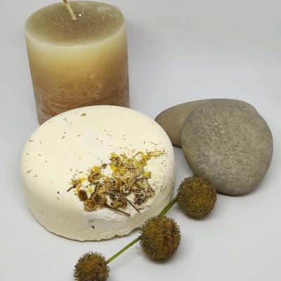 Velas, sabão com flores secas, pedras e frutos secos sobre fundo branco