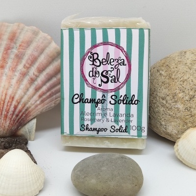 Champo sólido Beleza do Sal com embalagem às riscas verdes e brancas entre conchas e pedras