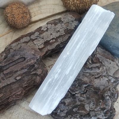 Barra branca translúcida sobre casca de árvore castanha e sementes marrons