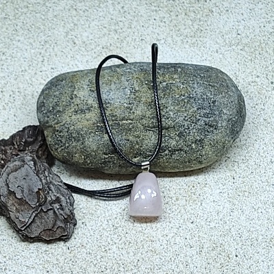 Colar com pendente de pedra rosa polida sobre pedra cinzenta
