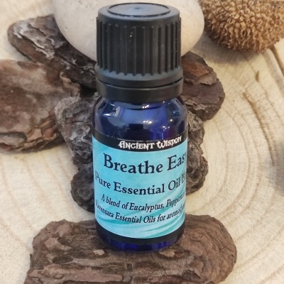 Frasco azul de óleo essencial sobre casca de árvore e pedras naturais