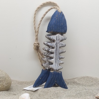 Figura decorativa de peixe esqueleto em madeira azul e branco com corda, sobre areia com conchas e pedra