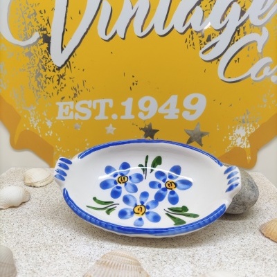 Prato decorativo de cerâmica com flores azuis e placa amarela Vintage ao fundo